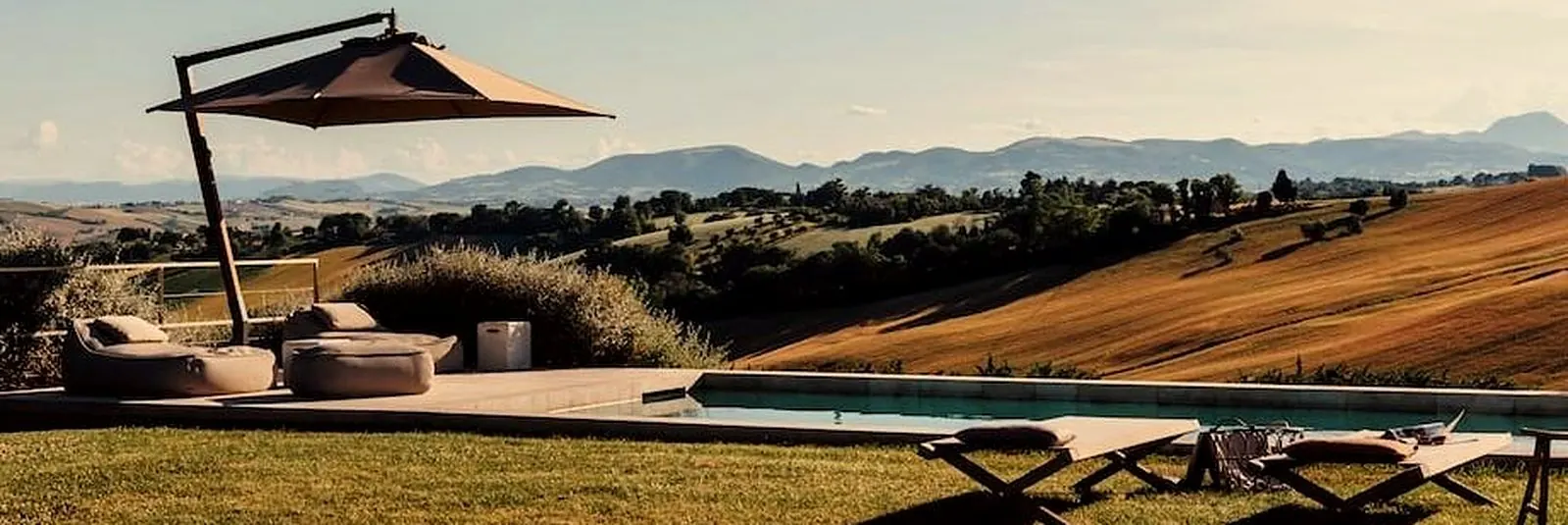 Pool overlooking the golden hills and mountains of Le Marche, Italy