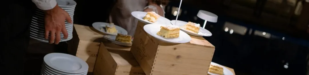 Slices of millefeuille wedding cake served on wooden wine crates by candlelight