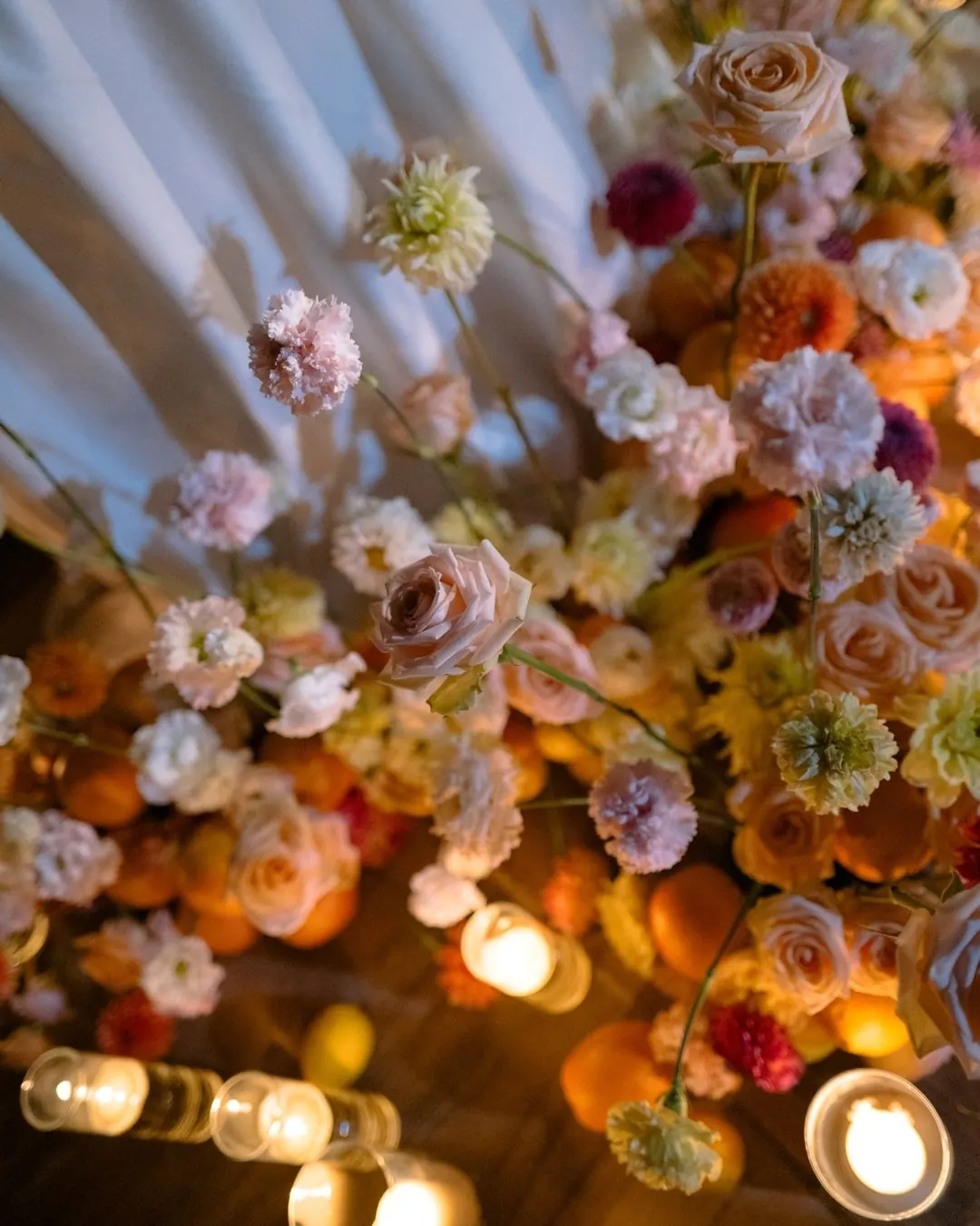 Wedding flowers, oranges and candles on a table in the evening
