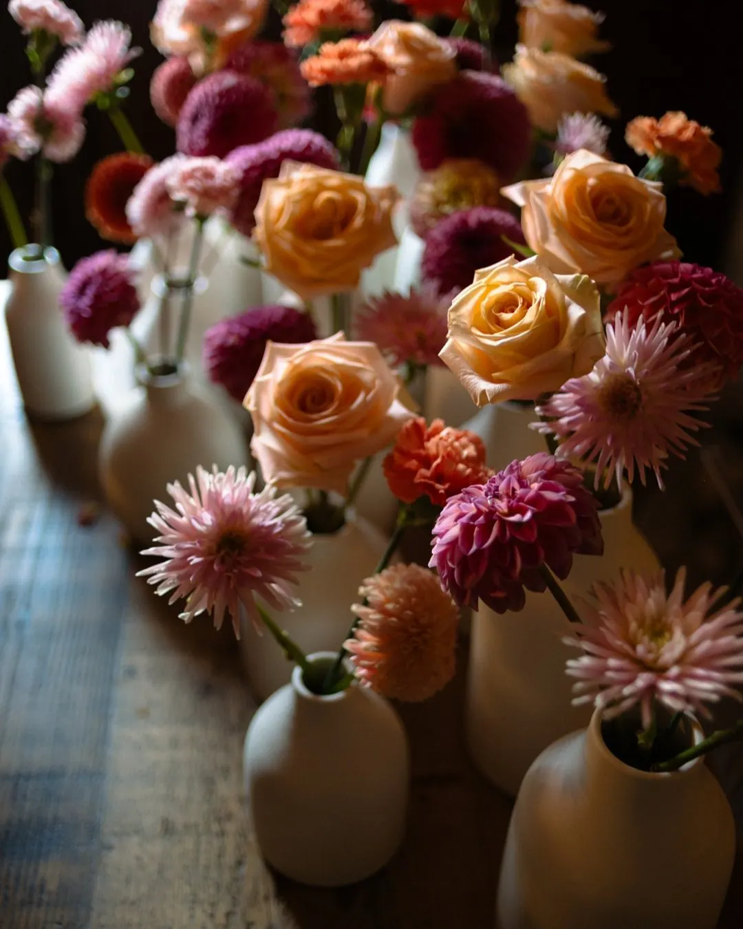 Wedding table flowers with peach roses and dahlias in ceramic vases
